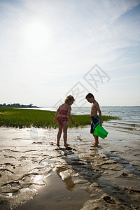 退潮时在海滩上玩耍的小孩图片