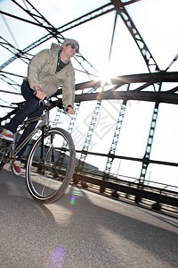 成人男性骑自行车过桥图片