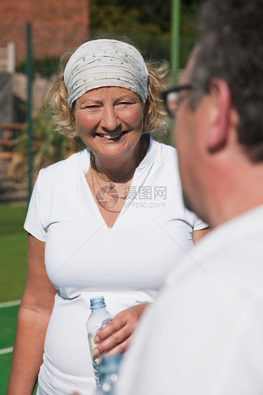 在网球场喝水休息的老年人图片