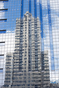 建筑物反映在摩天大楼玻璃中图片