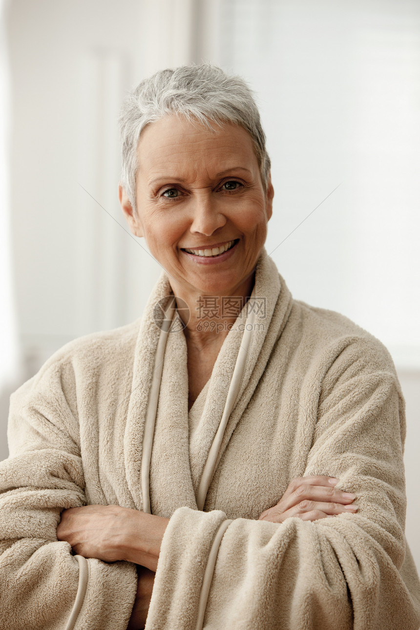 穿着浴袍微笑着的中年妇女图片