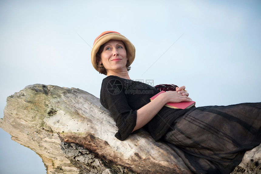 女人躺在漂浮木上图片