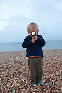 海滩上拿着手电筒的男孩图片