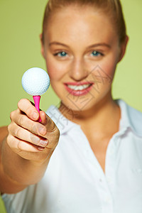 年轻女子手持高尔夫球背景图片