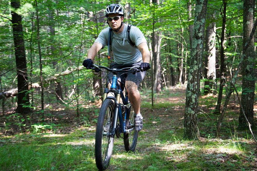 在森林中骑自行车的男性图片