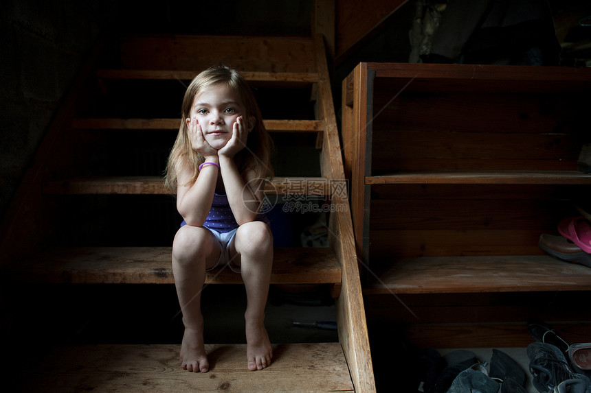 小女孩坐在地下室的楼梯上图片