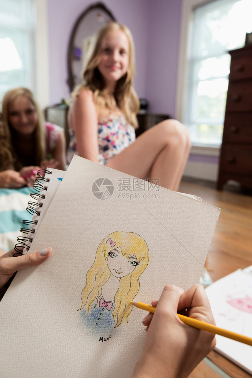 女孩在笔记本上画朋友的肖像图片