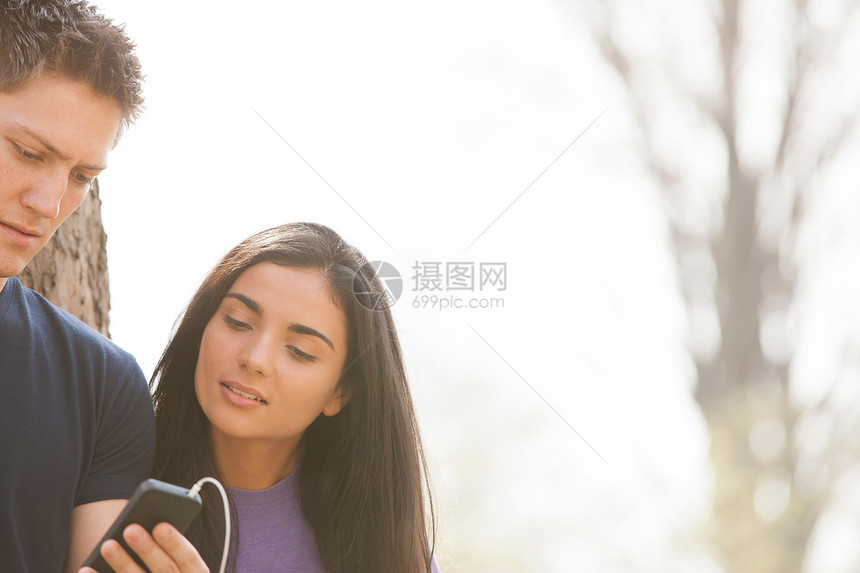 看智能手机的男青年和女青年图片