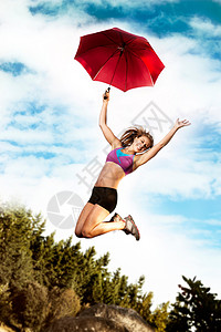 撑着雨伞起跳的女孩图片