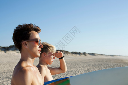 两个年轻的冲浪者前往大海图片