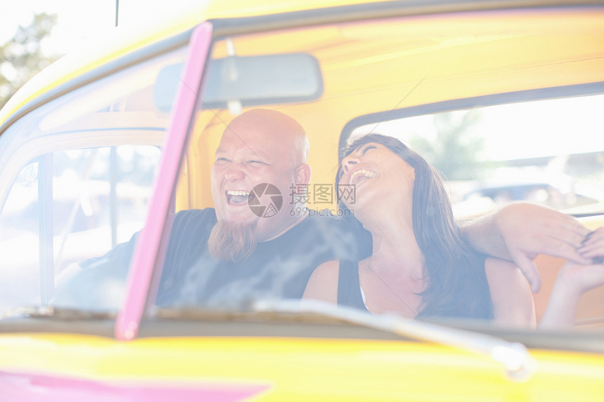 情侣在多彩的汽车中笑图片