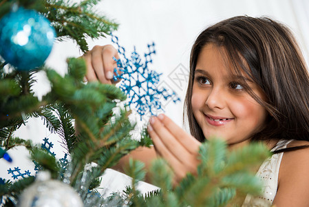 女孩笑着装饰圣诞树图片