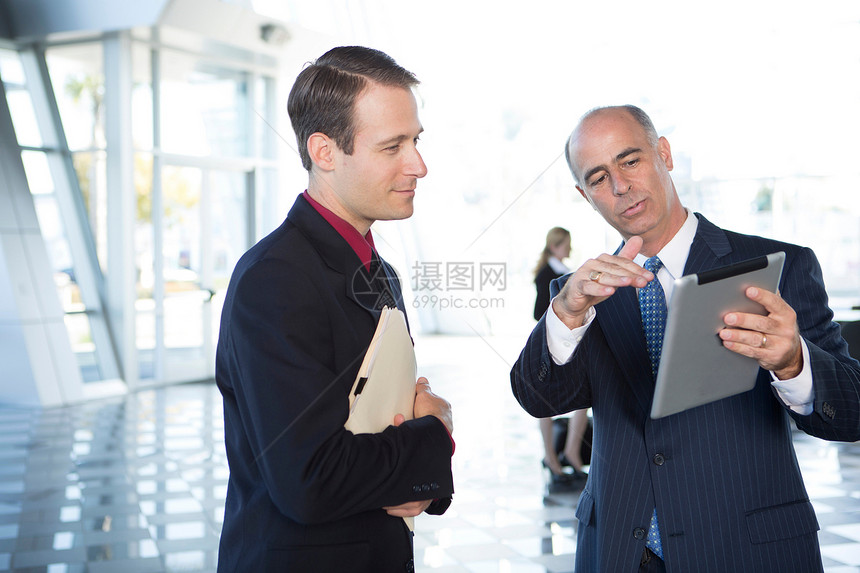 两名商人看着平板电脑讨论图片