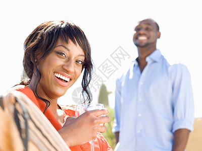 微笑的女人在户外喝水图片