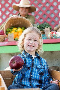 市场目光男孩在农民市场拿着苹果背景