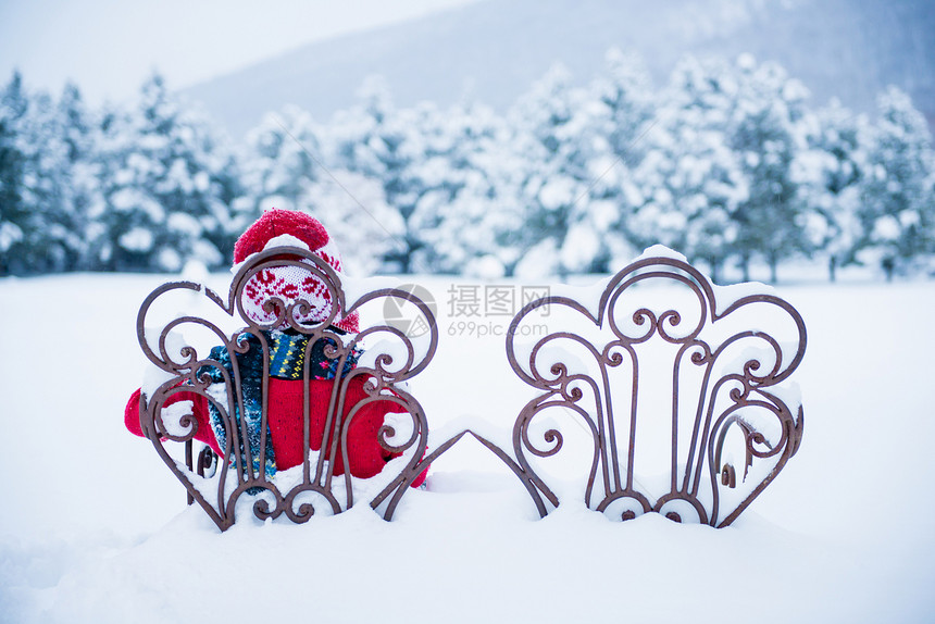 男孩坐在雪中的椅子上图片