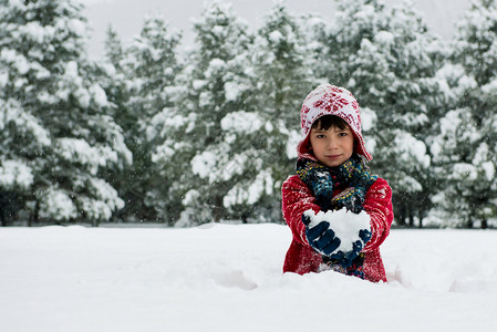 男孩在户外玩雪球图片