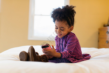 女孩在床上使用手机图片