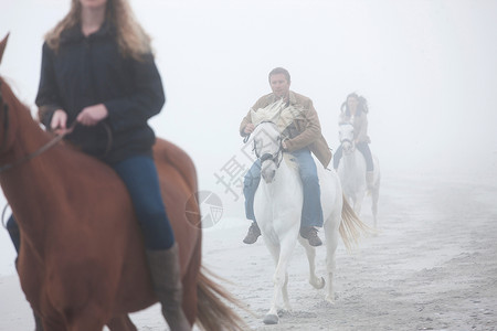 在海滩骑马的人图片