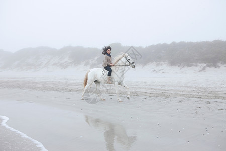 妇女在海滩骑马图片