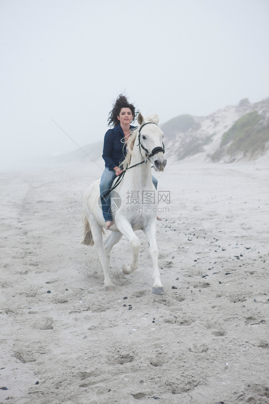 海滩上骑马的女人图片