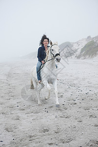 海滩上骑马的女人图片