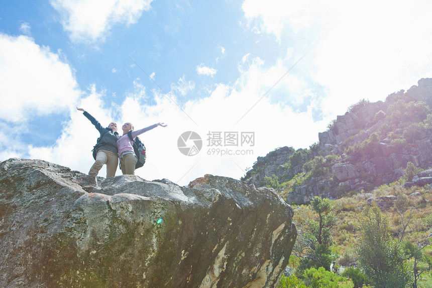 两个徒步旅行者在岩石上庆祝登顶图片