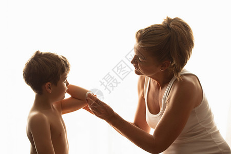 母亲用棉棒擦儿子的手肘图片