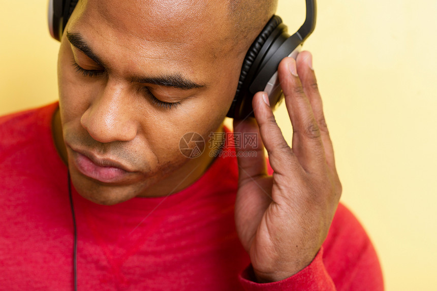 成年男子使用耳机听音乐图片