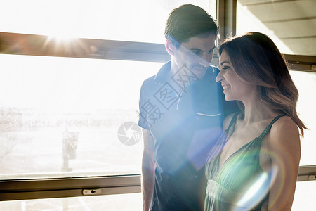 阳光照耀着窗边的年轻情侣图片