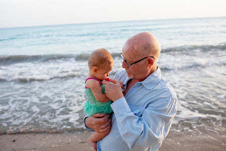 祖父和孙女在荷兰圣马丁海滩上图片