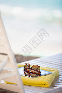 太阳遮光板上的墨镜毛巾和数字平板图片
