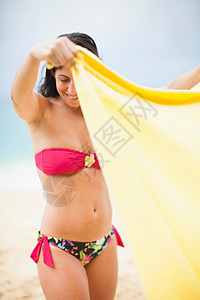 荷兰圣马丁岛海滩上拿着黄毛巾的女人图片