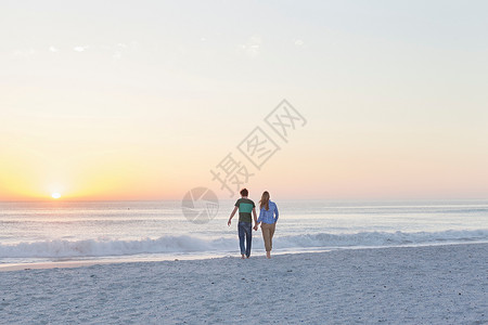 夫妇在海滩上手牵手行走图片