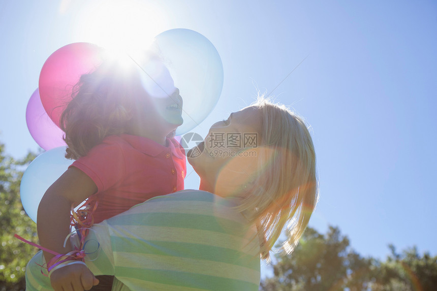 母亲在阳光下拥抱女儿气球图片