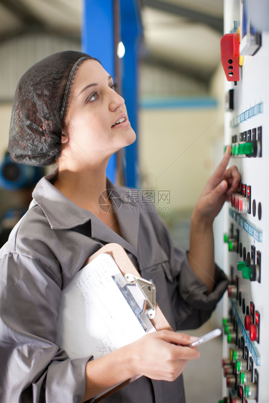 橄榄加工厂控制板上的妇女图片