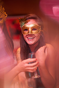 在派对上戴化妆面具的年轻女子图片