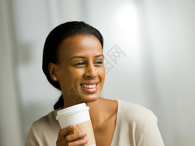 年轻女士拿着咖啡杯微笑图片
