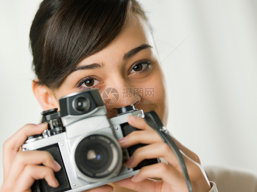 青年妇女拿着照相机拍照图片