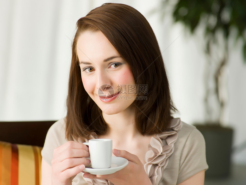 年轻女士拿着咖啡杯微笑 图片