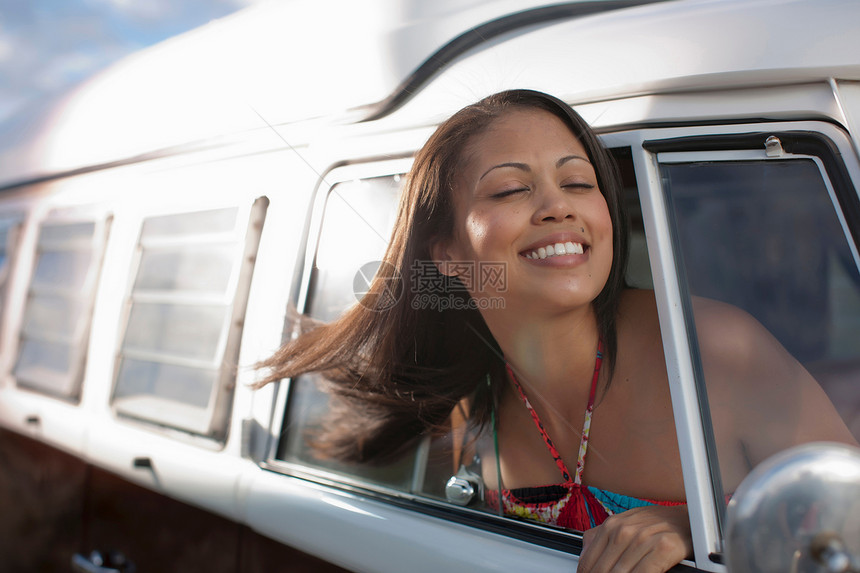 年轻女士从露营车窗外微笑着图片