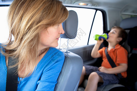 男孩在汽车后座喝水图片