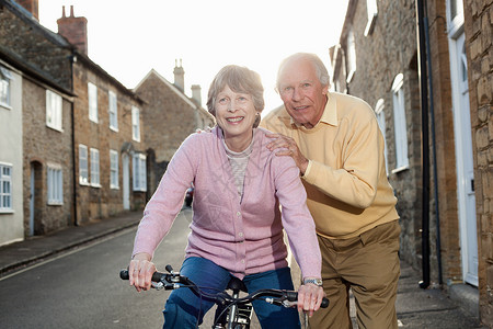 丈夫扶着妻子学自行车背景图片