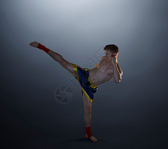 摄影棚拍摄的年轻男拳手踢腿图片