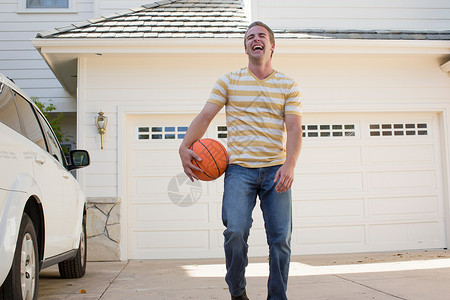 年轻人拿着篮球大笑图片