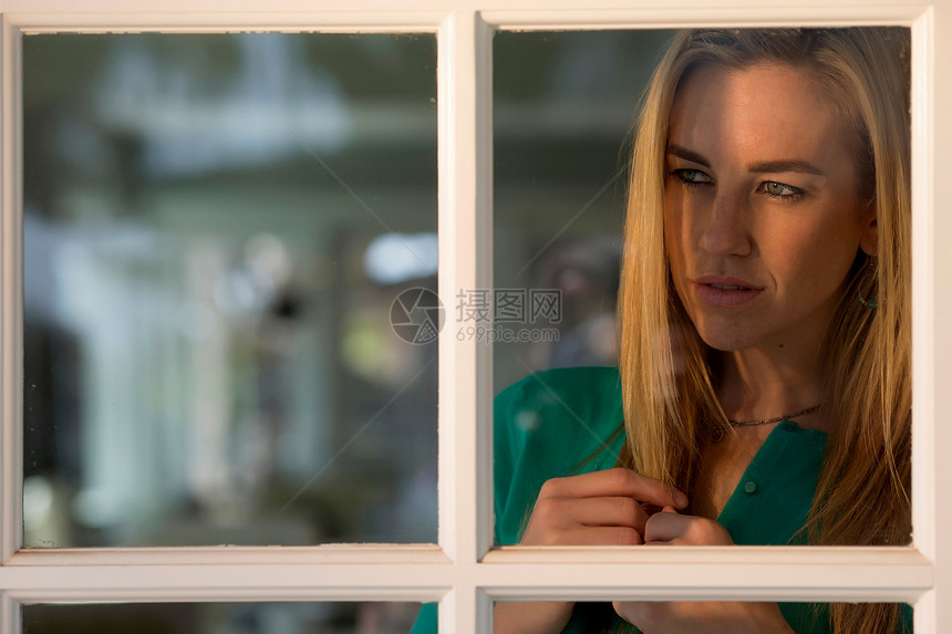 年轻女往向窗看景色图片