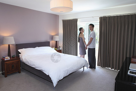 卧室顶灯酒店度假的年轻夫妻背景
