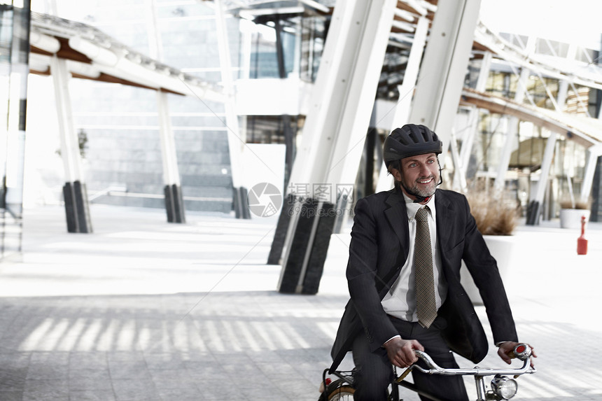 在城市骑自行车的中年男性图片