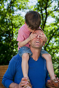 儿童骑在父亲的肩上背景图片