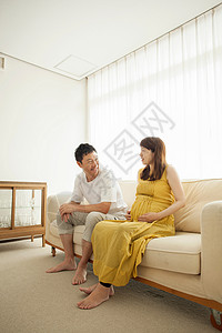 坐在沙发上的成熟男性和孕妇图片